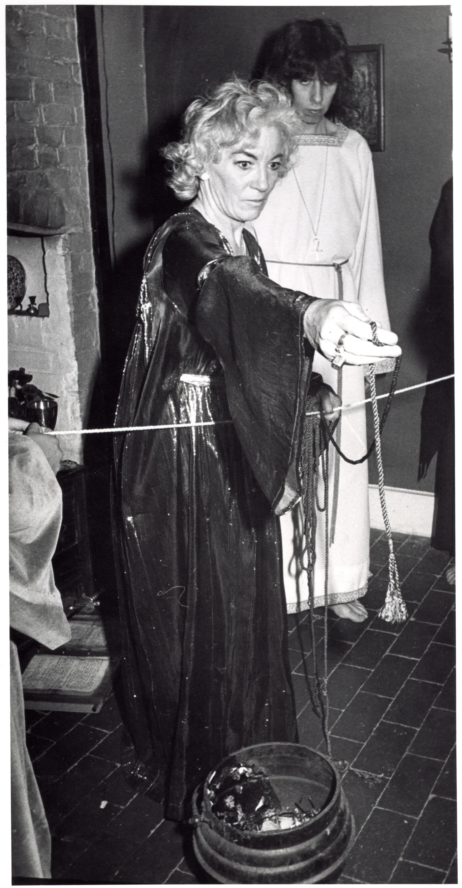 Betty Britton holding a cord over the cauldron, Chantry Cottage, 2 July 1974