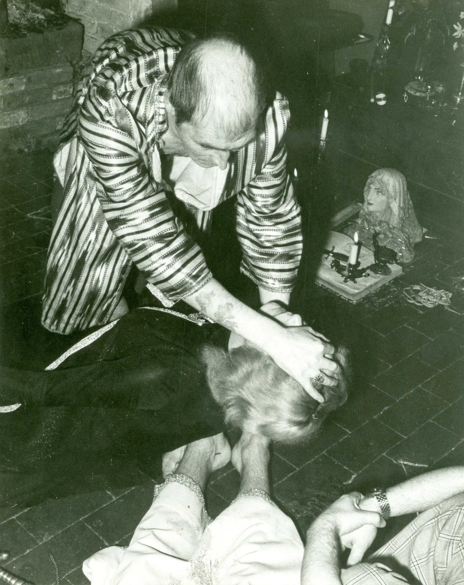 Alex Sanders with a coven member lying on the floor, Chantry Cottage, 23 April 1975